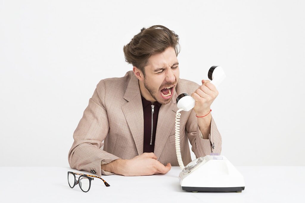 Man stressed on phone representing debt collector harassment