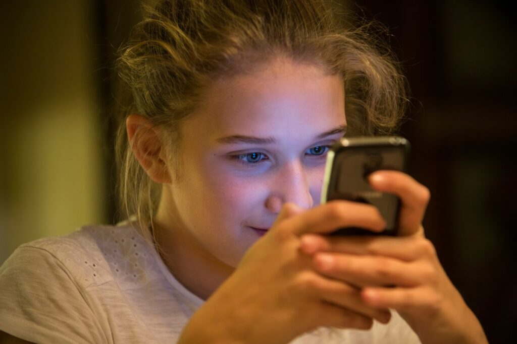 Young person using smartphone - Photo by Johnny Cohen on Unsplash