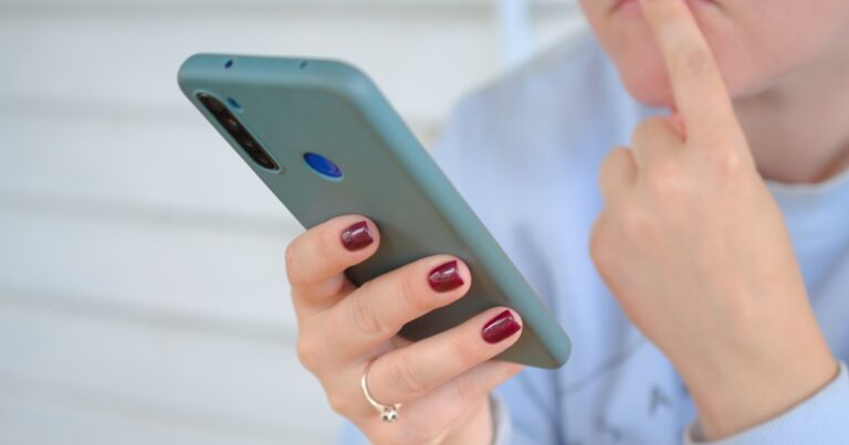 Person holding phone representing cyberbullying and online harassment claims in the UK