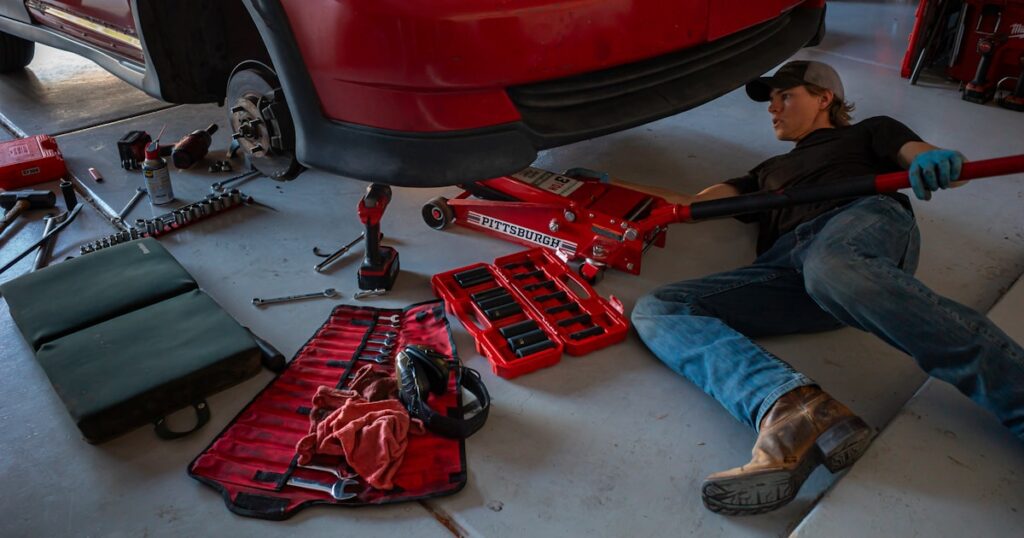 Mechanic working on car representing garage fraud claims in the UK