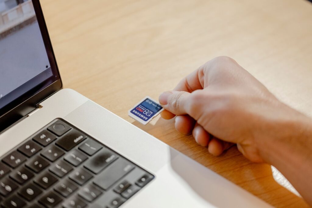 Person holding credit card in front of laptop for online subscription