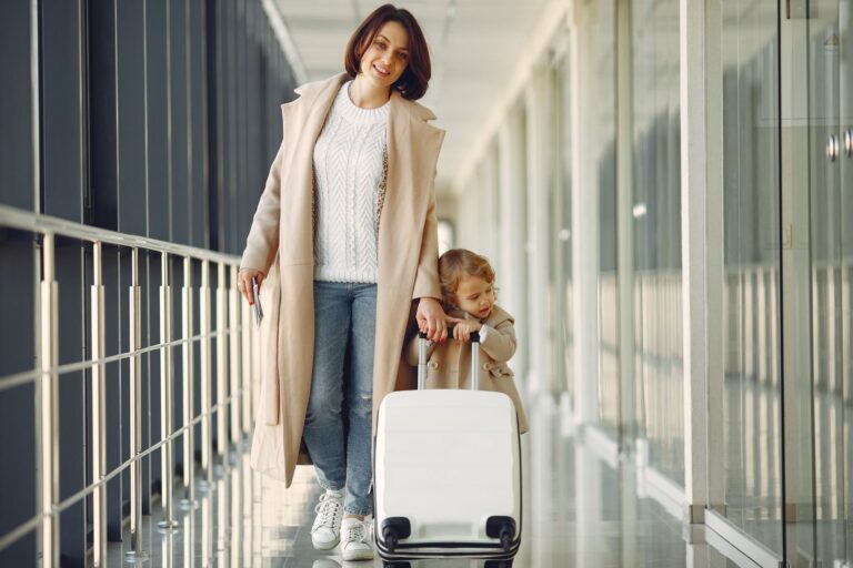 Mother and daughter with suitcase walking in an airport corridor