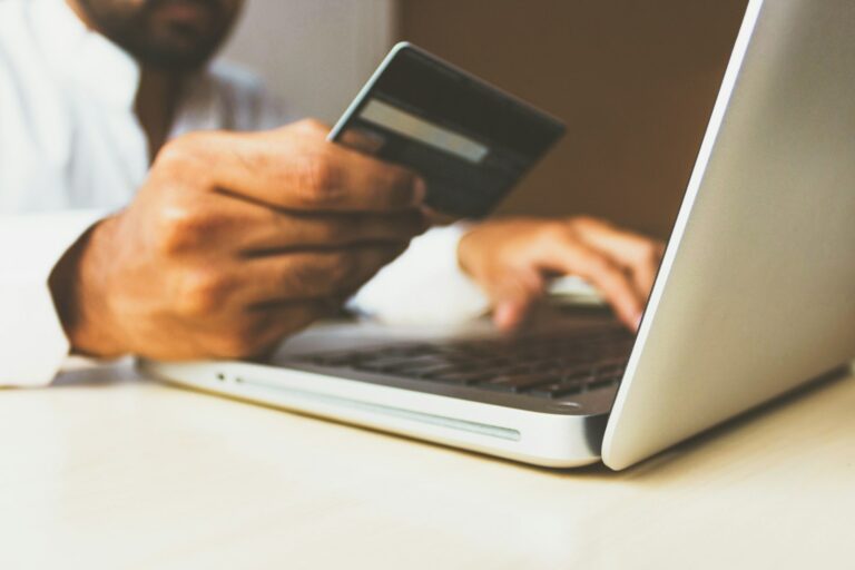 Person reviewing online banking security on a laptop with a payment card nearby