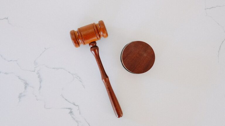 Wooden judge gavel on white marble surface representing a workplace injury lawsuit question