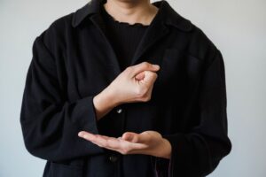 Close-up of a person using American Sign Language, representing effective communication access.