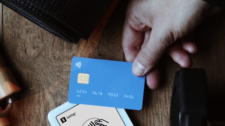 A person pays for a gym membership with a card at a reception desk