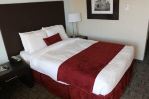 A neatly made hotel bed in a guest room, used to illustrate hotel bed bug injury claims.