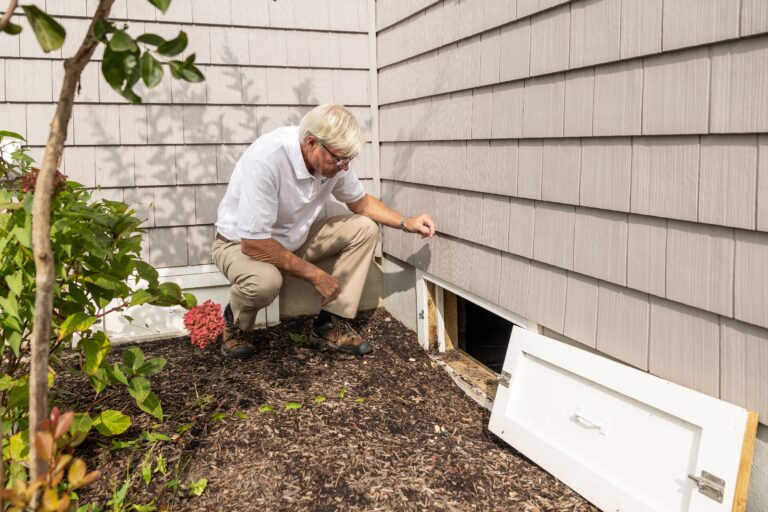Home inspector examining crawl space