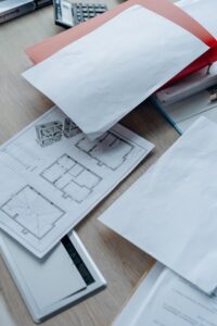 Architectural plans and permit paperwork on an office desk