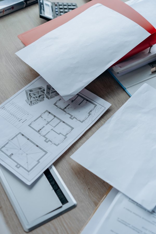 Architectural plans and permit paperwork on an office desk